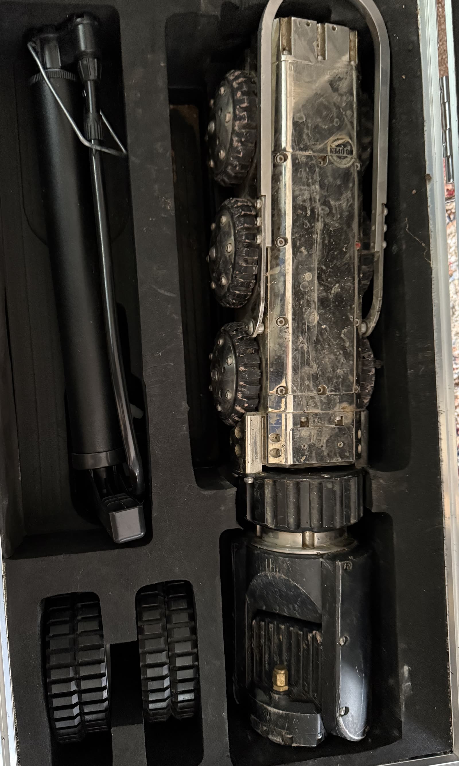 ARPCO's CCTV pipe crawler lying in its fitted field case, with its spare wheel sets and push rod beside it
